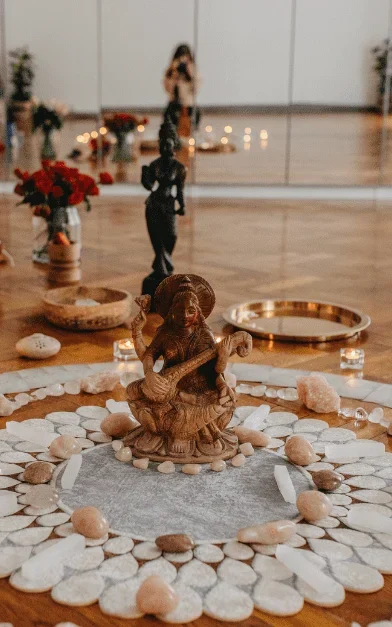 Meditační prostor se soškou a kruhem z kamenů při svíčkách